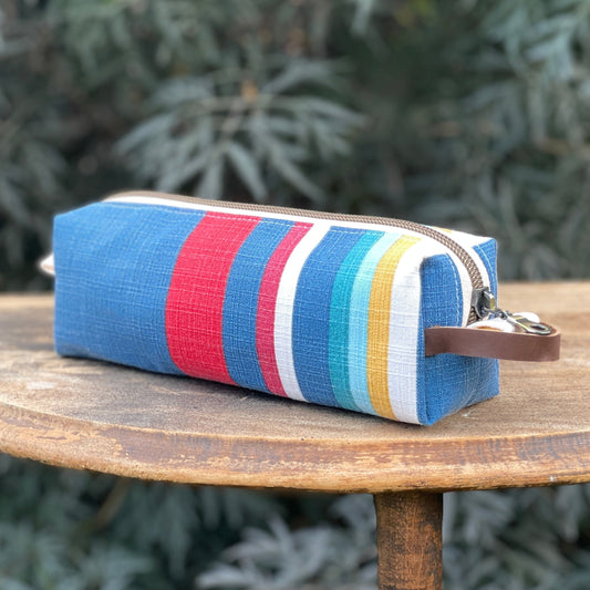 Striped pouch with colorful pattern on a wooden table outdoors